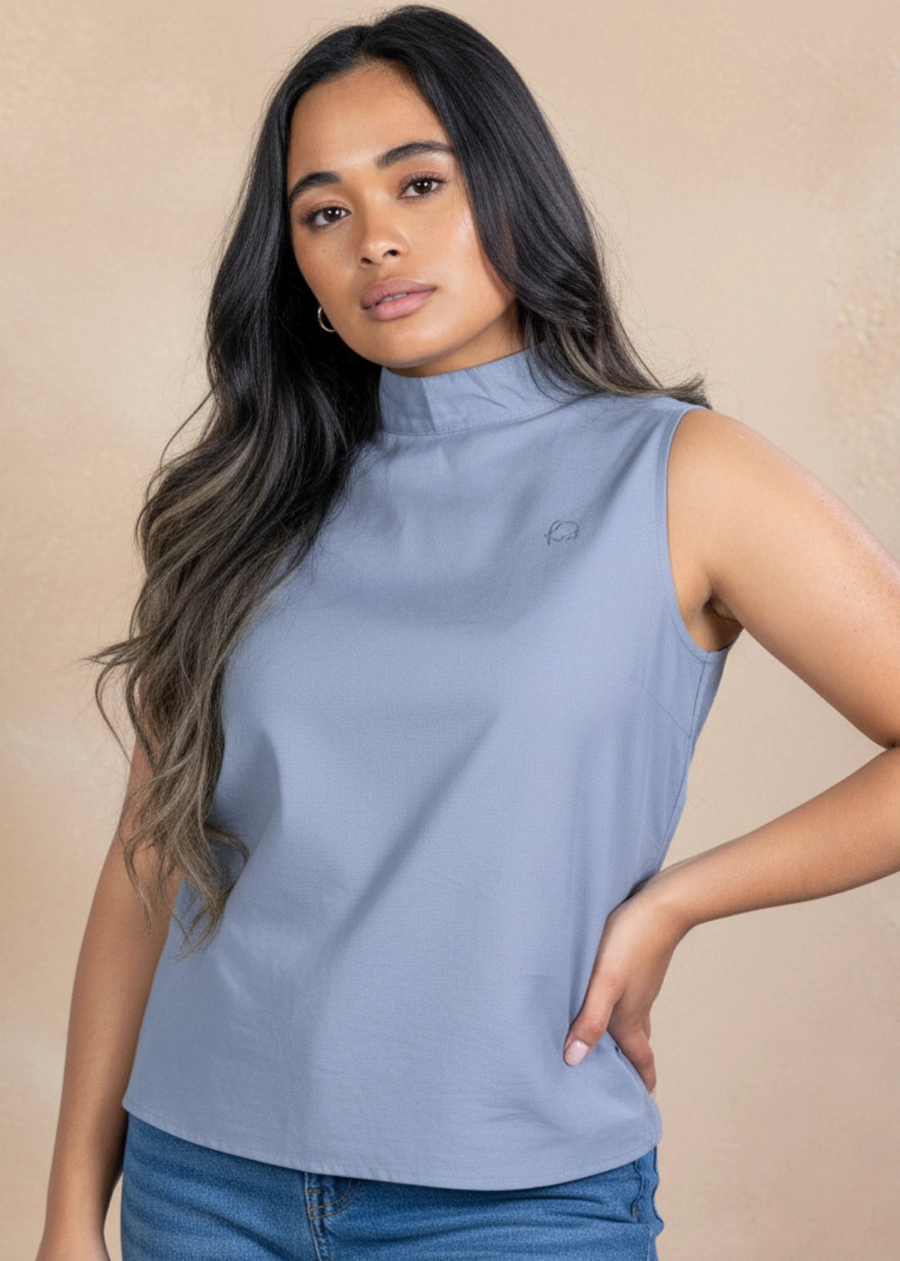 Woman wearing grey sleeveless linen–cotton top with mock neck.