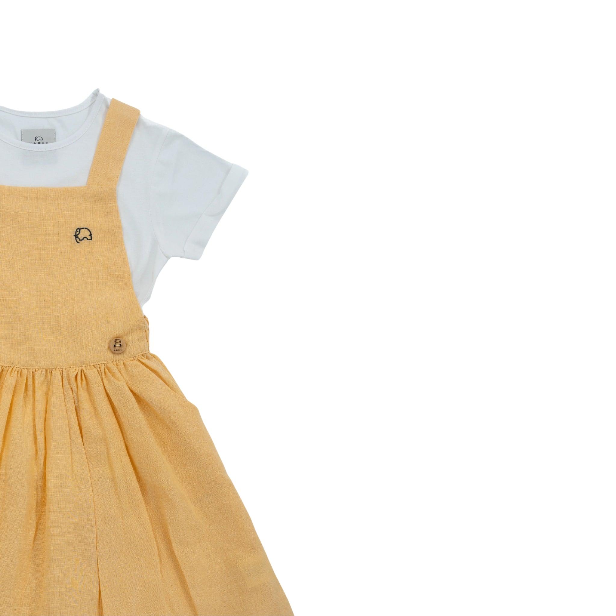 A yellow toddler's Golden Fleece Linen Pinafore by Karee with a white undershirt, featuring a small embroidered animal on the chest, displayed against a white background.