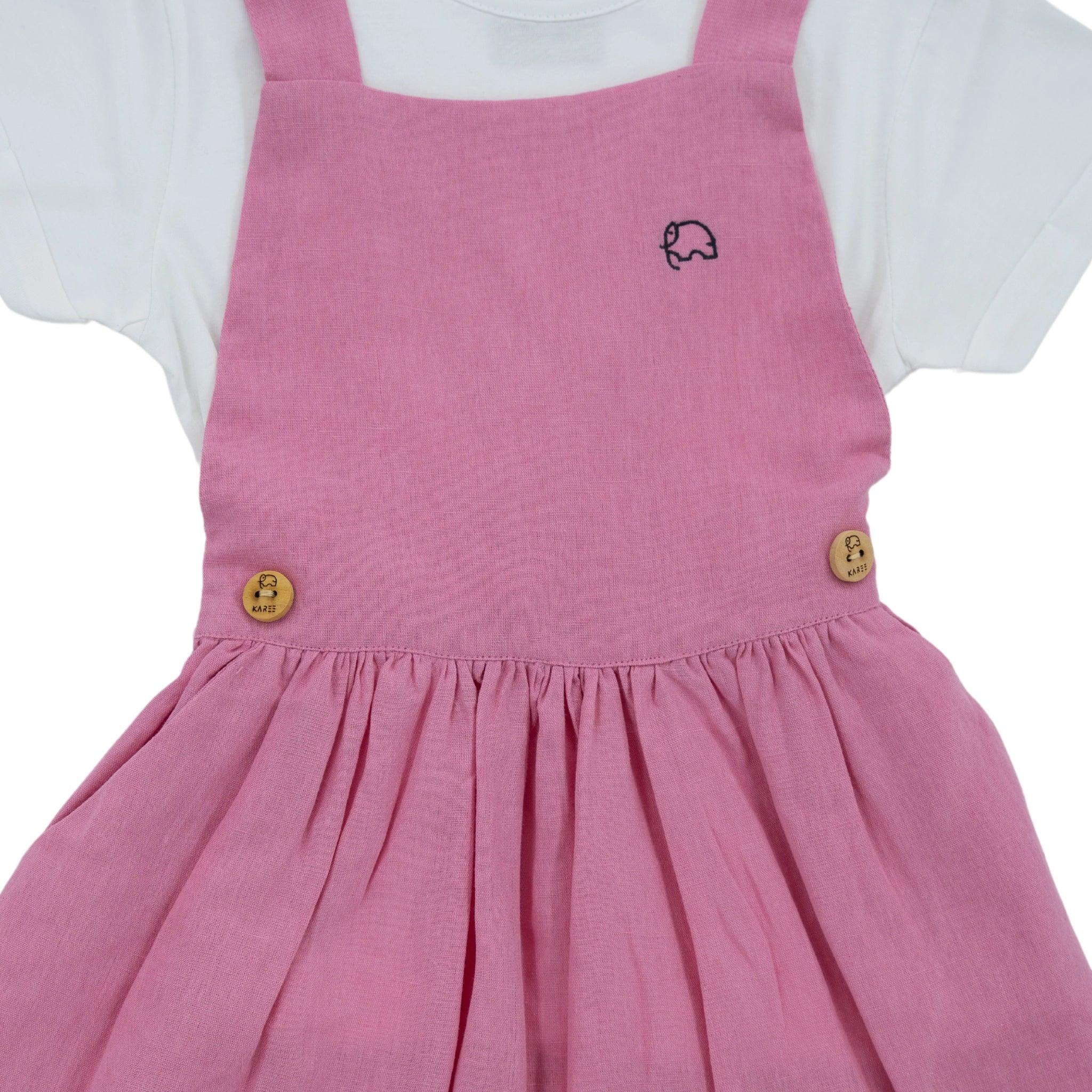 Karee Cashmere Rose Linen Pinafore dress with white shirt, featuring embroidered car on the bib and wooden buttons.