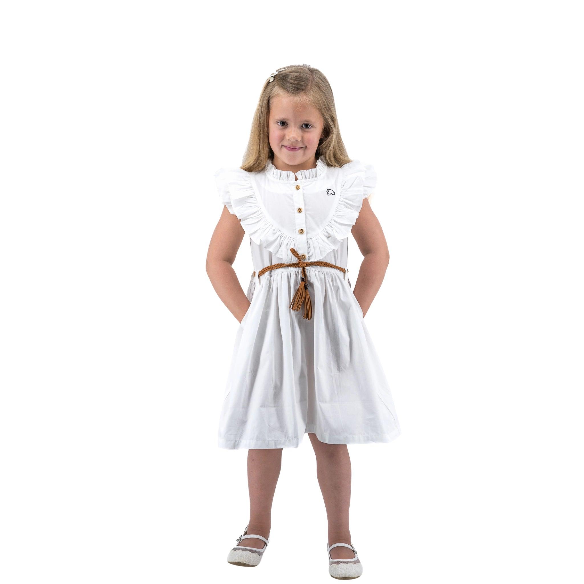 Young girl in a Karee Butterfly Sleeve Cotton Dress in White with a brown belt, smiling and posing on a white background.