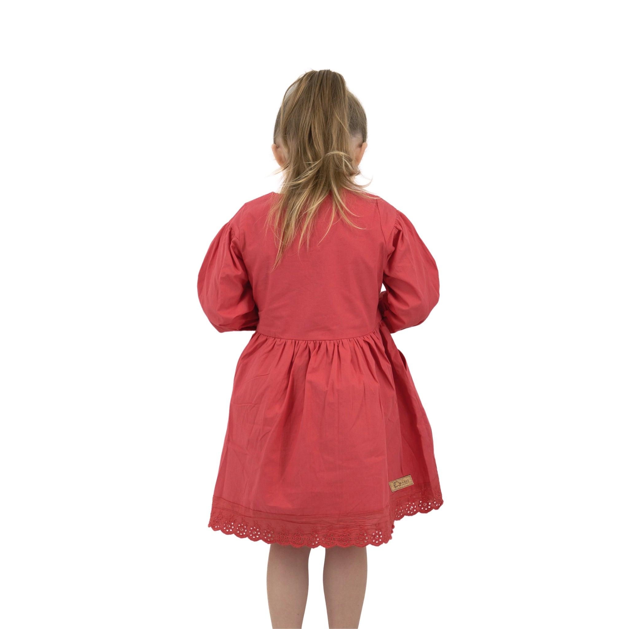 Young girl in a Karee red long puff sleeve cotton dress with lace trim, viewed from the back, standing against a white background.