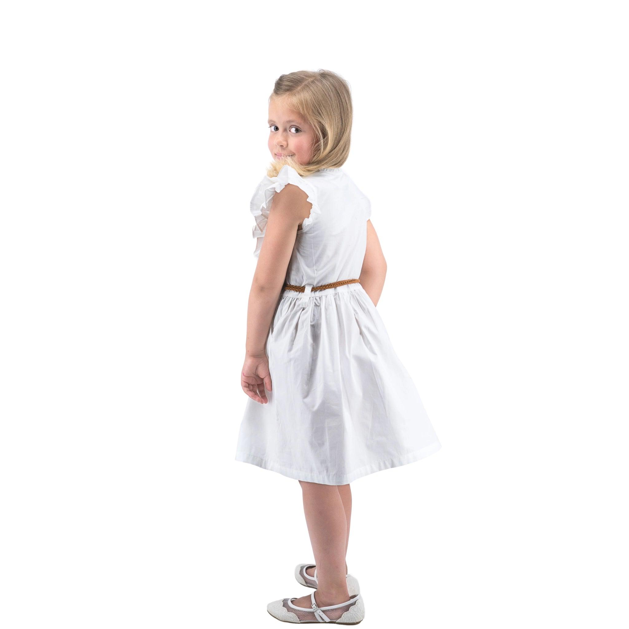 Young girl in a Karee Butterfly Sleeve Cotton Dress in White, looking over her shoulder, standing against a white background.