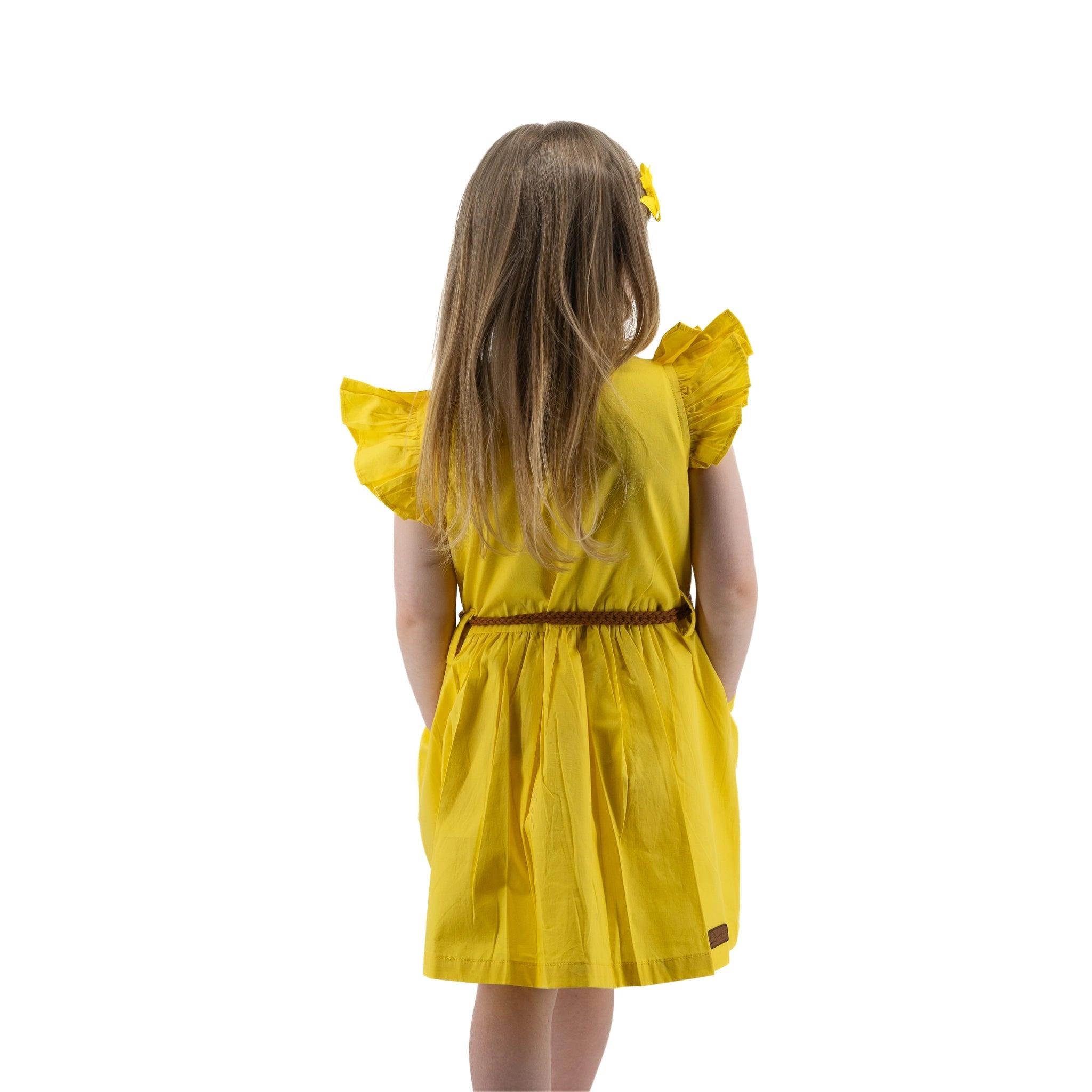 Young girl in a Karee Yellow Butterfly Sleeve Cotton Dress For Girls facing away, with a yellow hair bow, isolated on a white background.