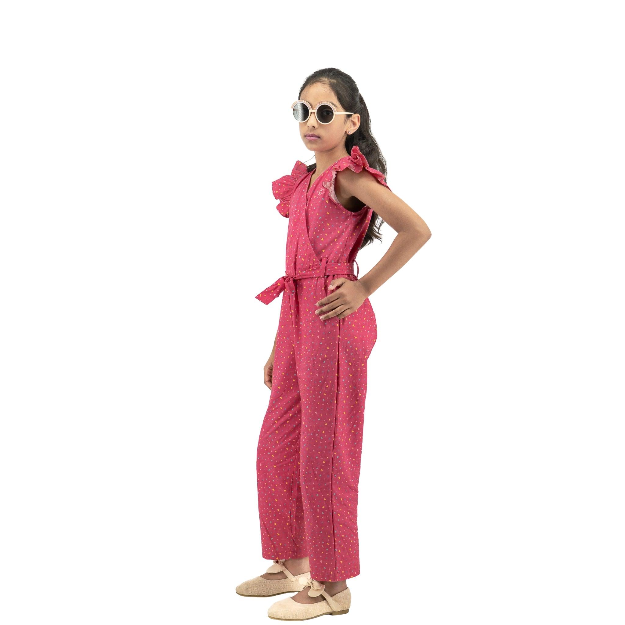 Young girl wearing a Karee Red Rose Cotton Jumpsuit for Girls and large sunglasses, posing with hands on hips against a white background.