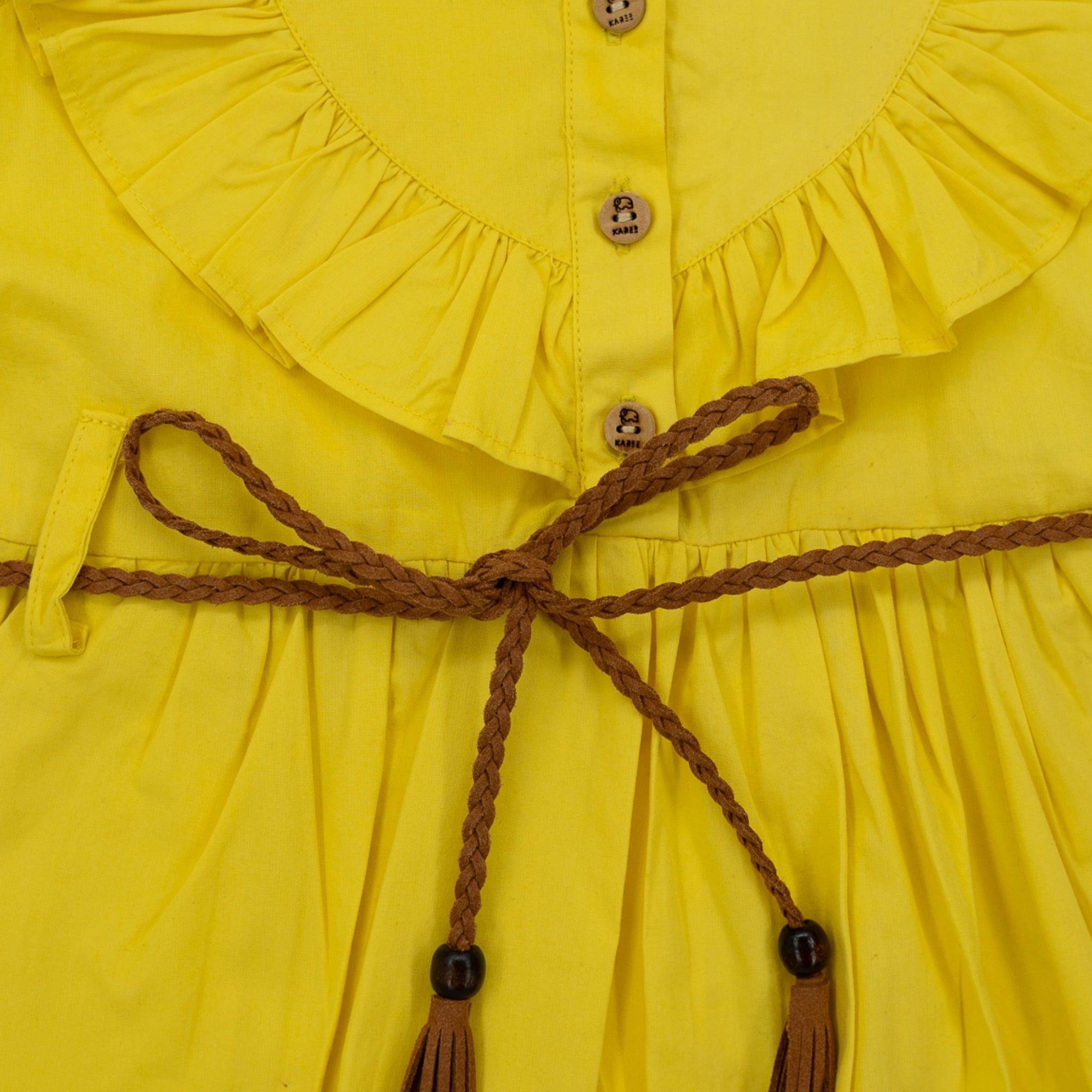 Close-up of a Karee yellow butterfly sleeve cotton dress for girls with a braided brown belt tied in a bow at the waist, featuring a ruffled neckline and wooden buttons.