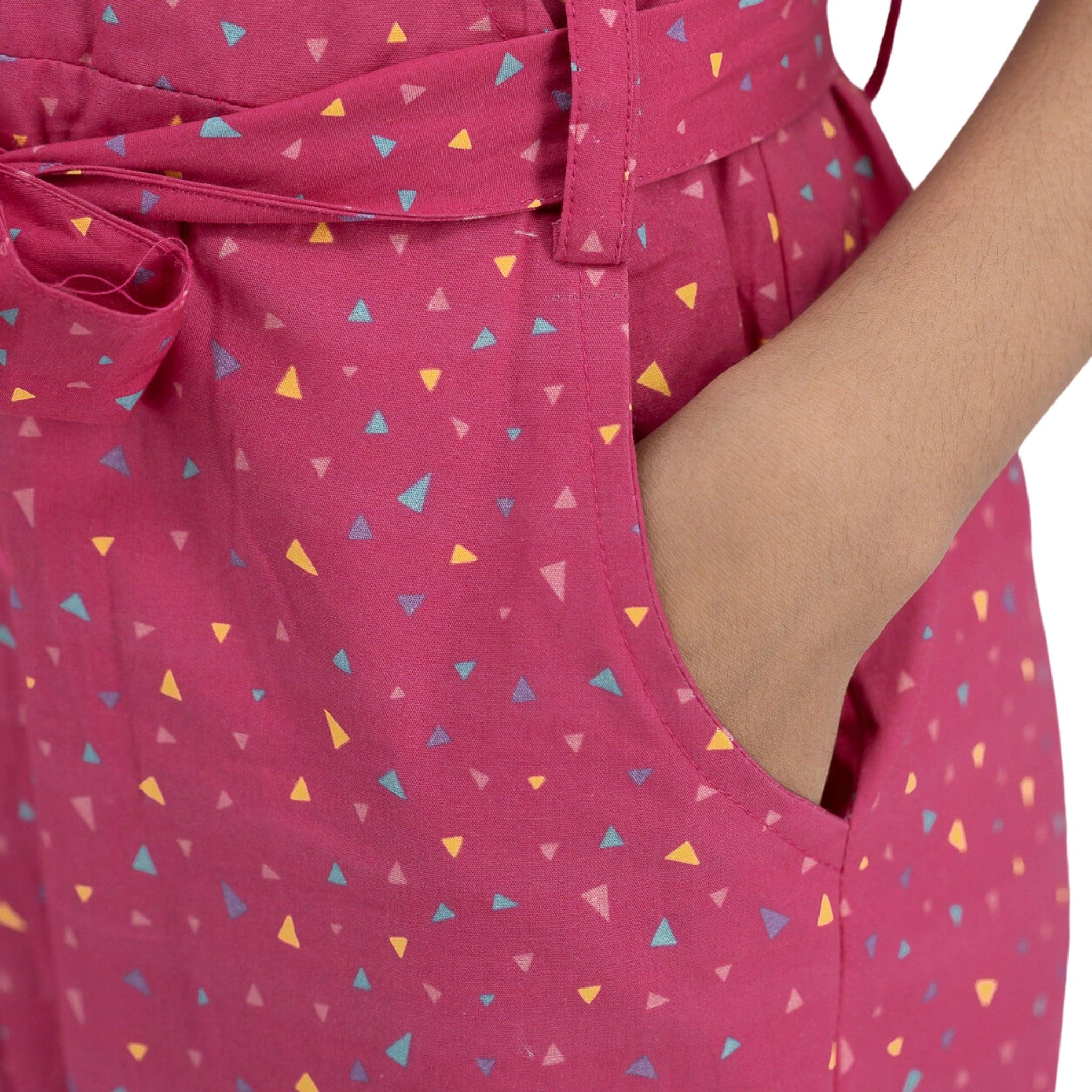 Close-up of a person wearing a Red Rose Cotton Jumpsuit for Girls by Karee, with a colorful triangle pattern, focusing on the waist tie detail.