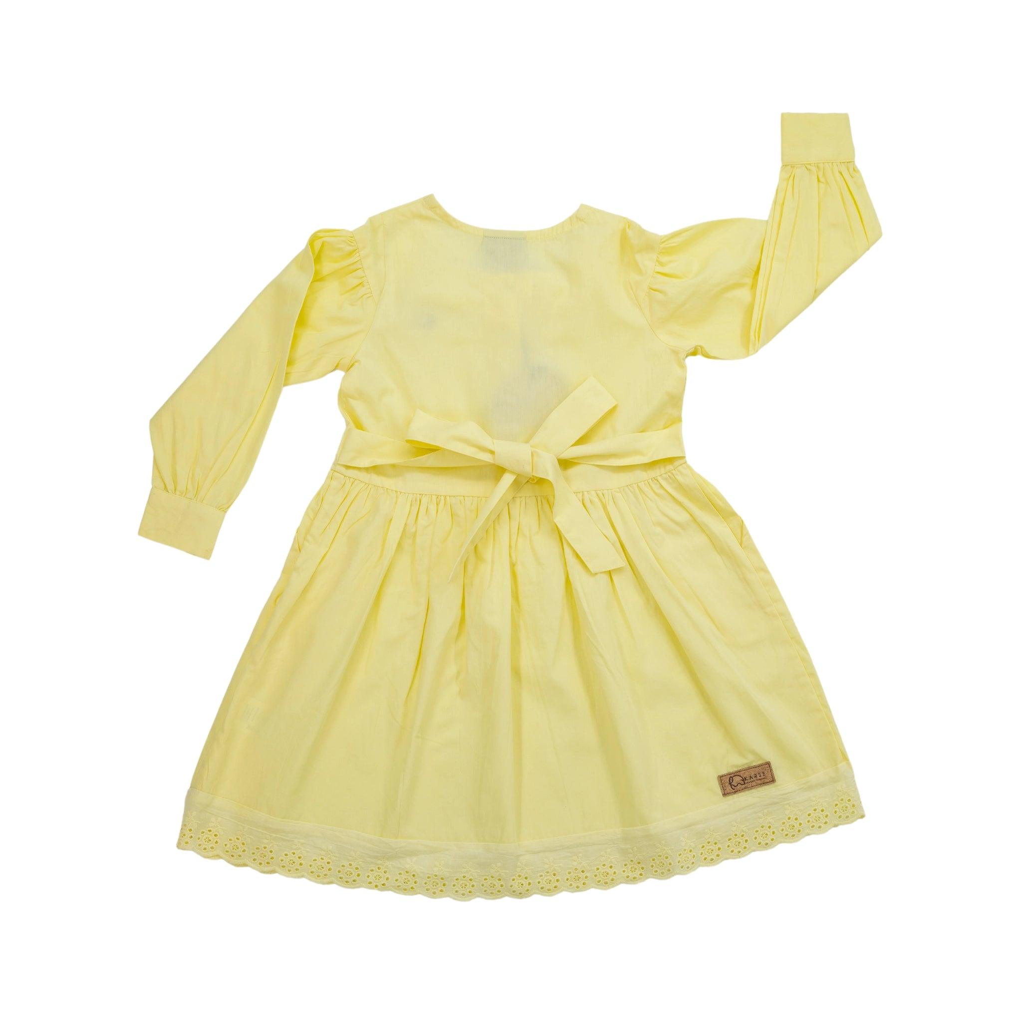 A pale yellow children's dress with long puff sleeves, a waist bow, and lace detailing at the hem, displayed against a white background. (Yellow Long Puff Sleeve Cotton Dress by Karee)