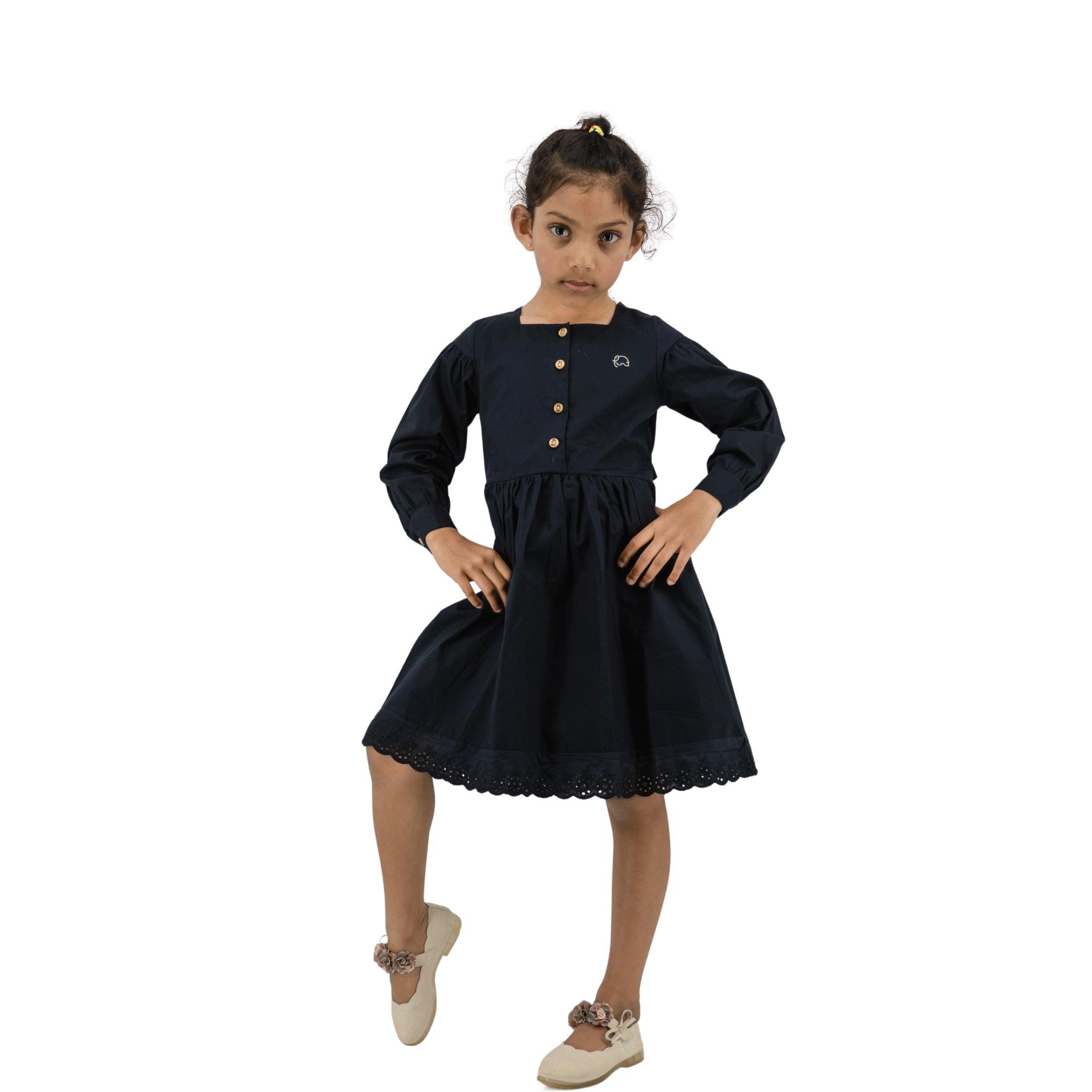 Young girl in a navy blue dress with long puff sleeves standing confidently with hands on her hips against a white background.

Product Name: Black Long Puff Sleeve Cotton Dress
Brand Name: Karee

Revised Sentence: Young girl in a Karee black long puff sleeve cotton dress standing confidently with hands on her hips against a white background.