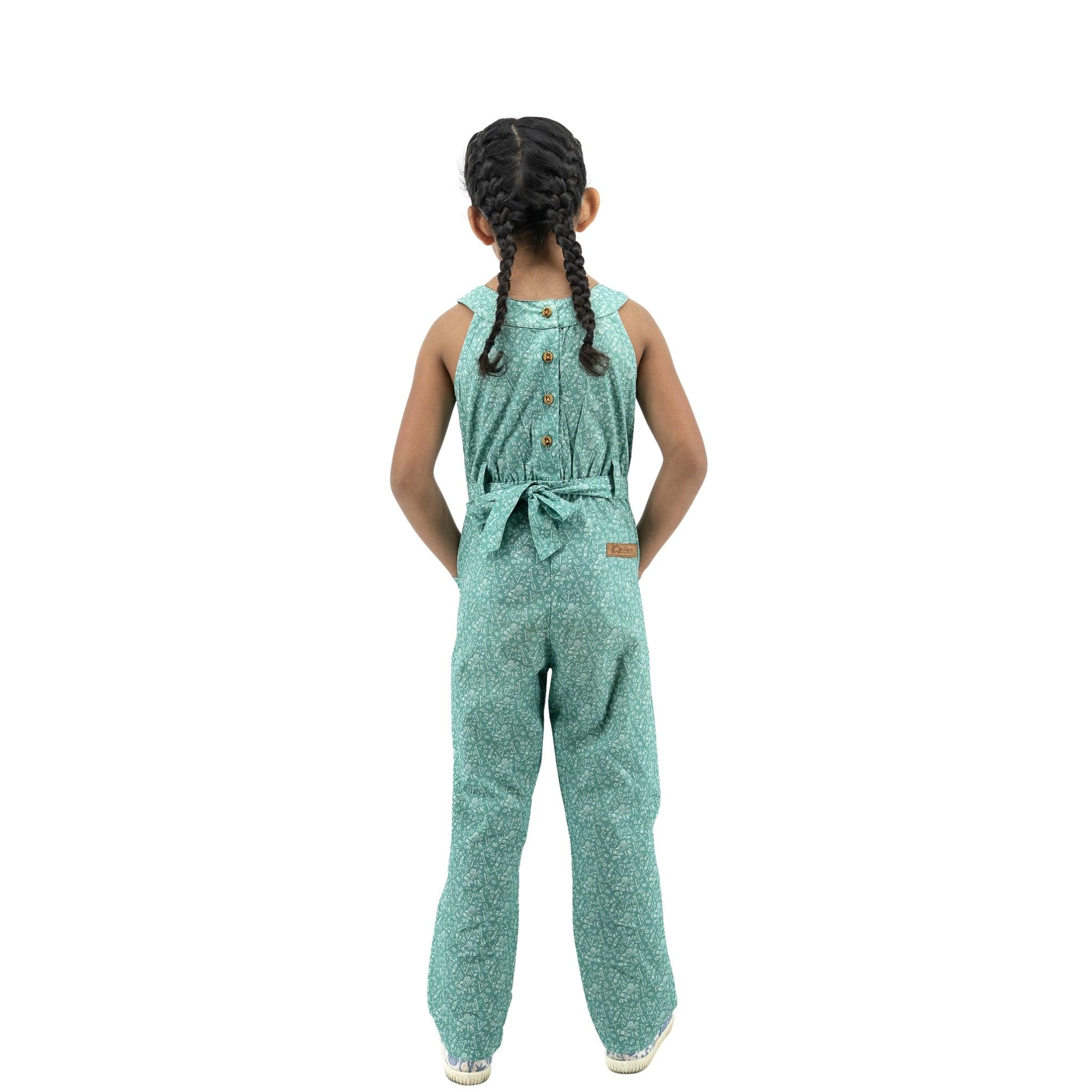A young girl seen from behind, wearing a Karee Smoke Green Cotton Jumpsuit For Girls and braided hair, standing against a white background.