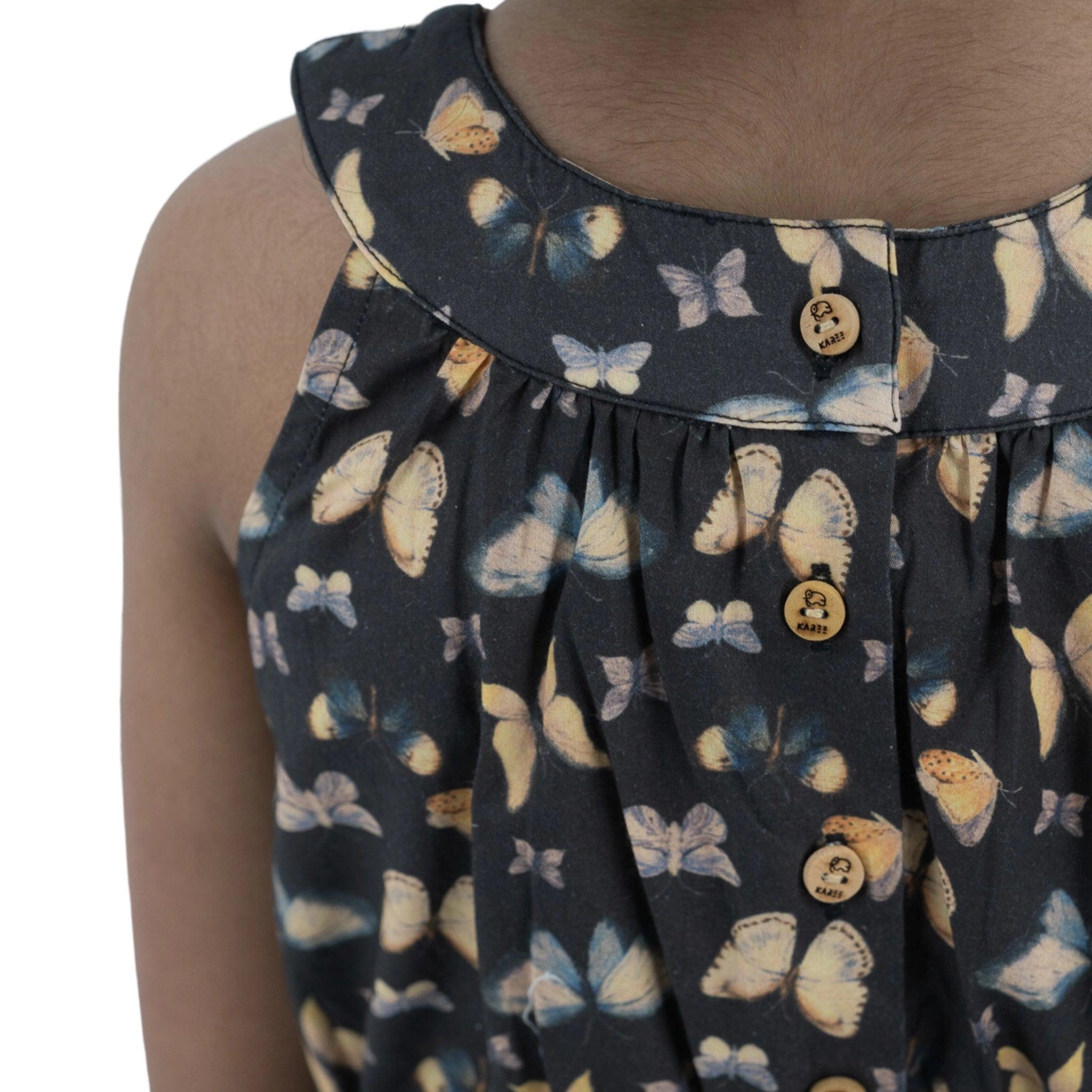 Close-up of a woman wearing a Karee Pirate Black Adventure-ready Cotton Play Suit with a butterfly pattern and round, brown buttons on the collar, complemented by a waist belt.
