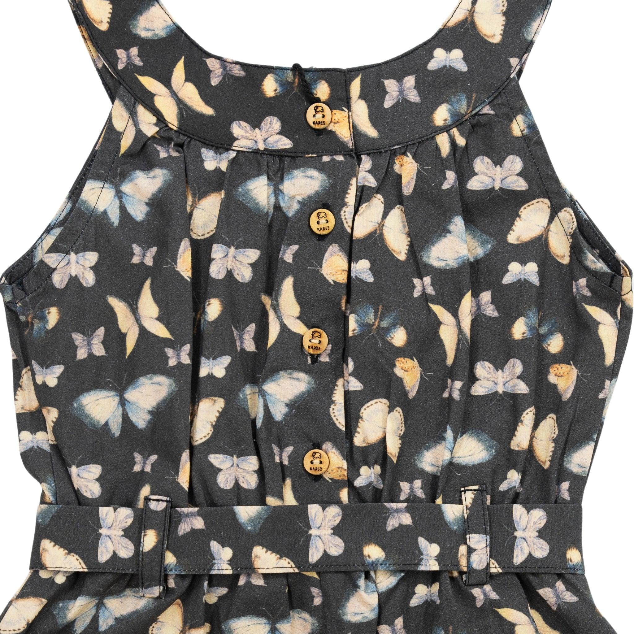 Close-up of a Pirate Black Adventure-ready Cotton Play Suit by Karee, featuring a butterfly print, pleats, button details, and a waist belt.