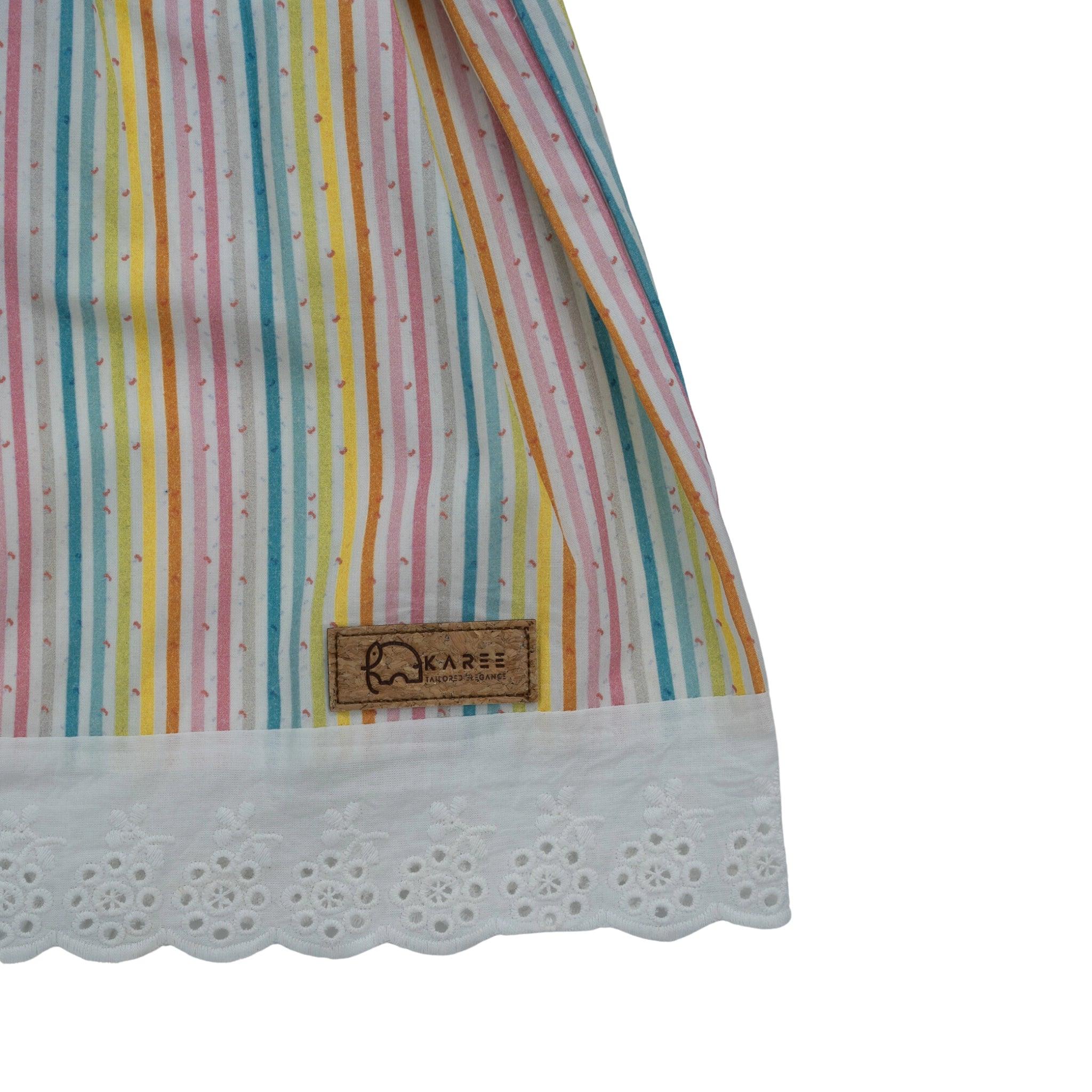 Striped fabric with a wooden Karee tag and a white lace trim on a white cotton background.