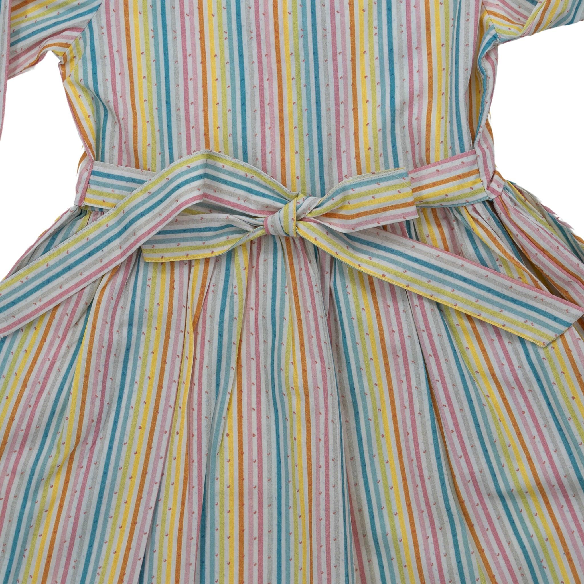 A colorful striped dress with a bow at the back, featuring vertical pastel stripes in yellow, pink, blue, and green, designed as part of Karee's sustainable fashion initiative.