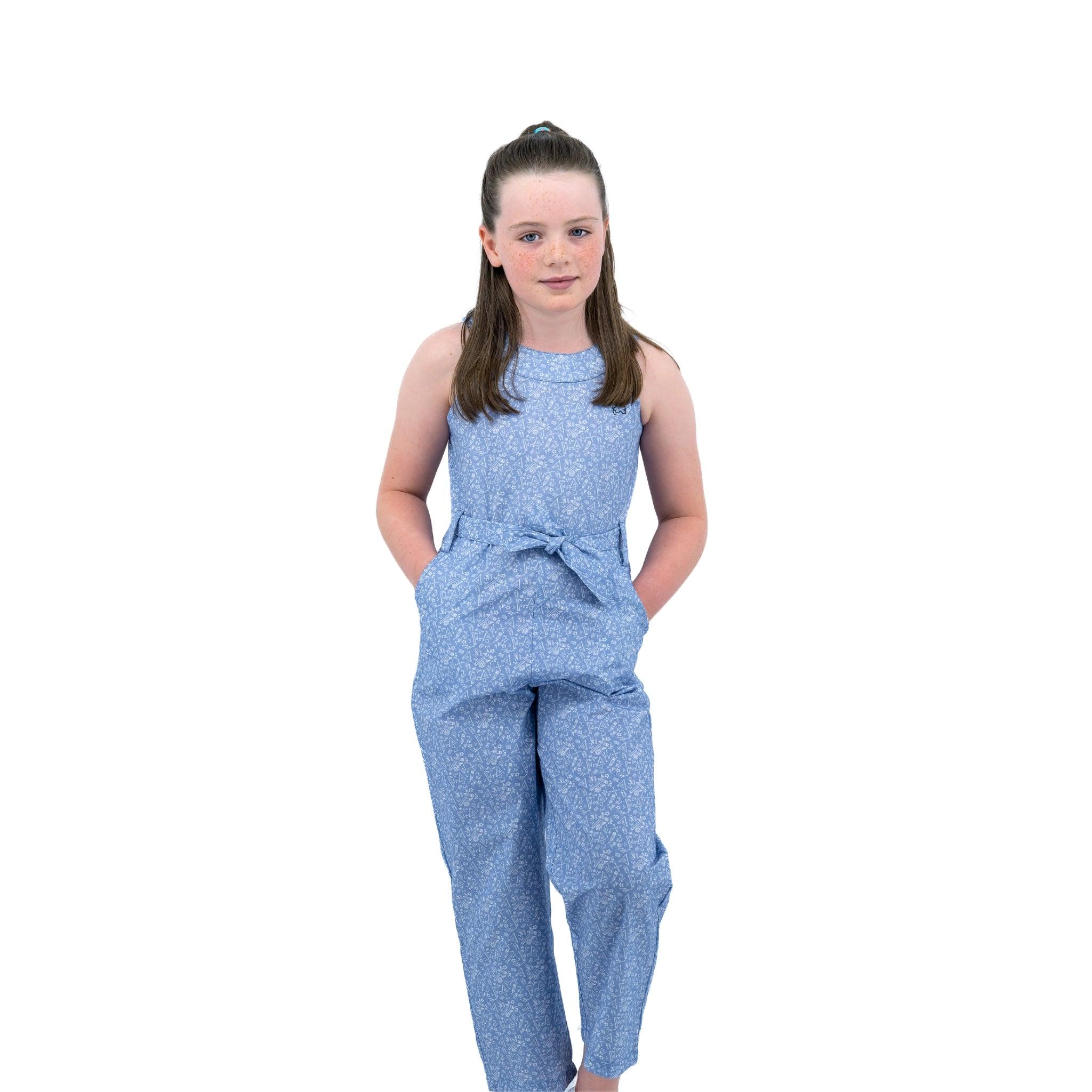 A young girl stands posing in a Karee Purple Impression Cotton Jumpsuit for kids against a white background.