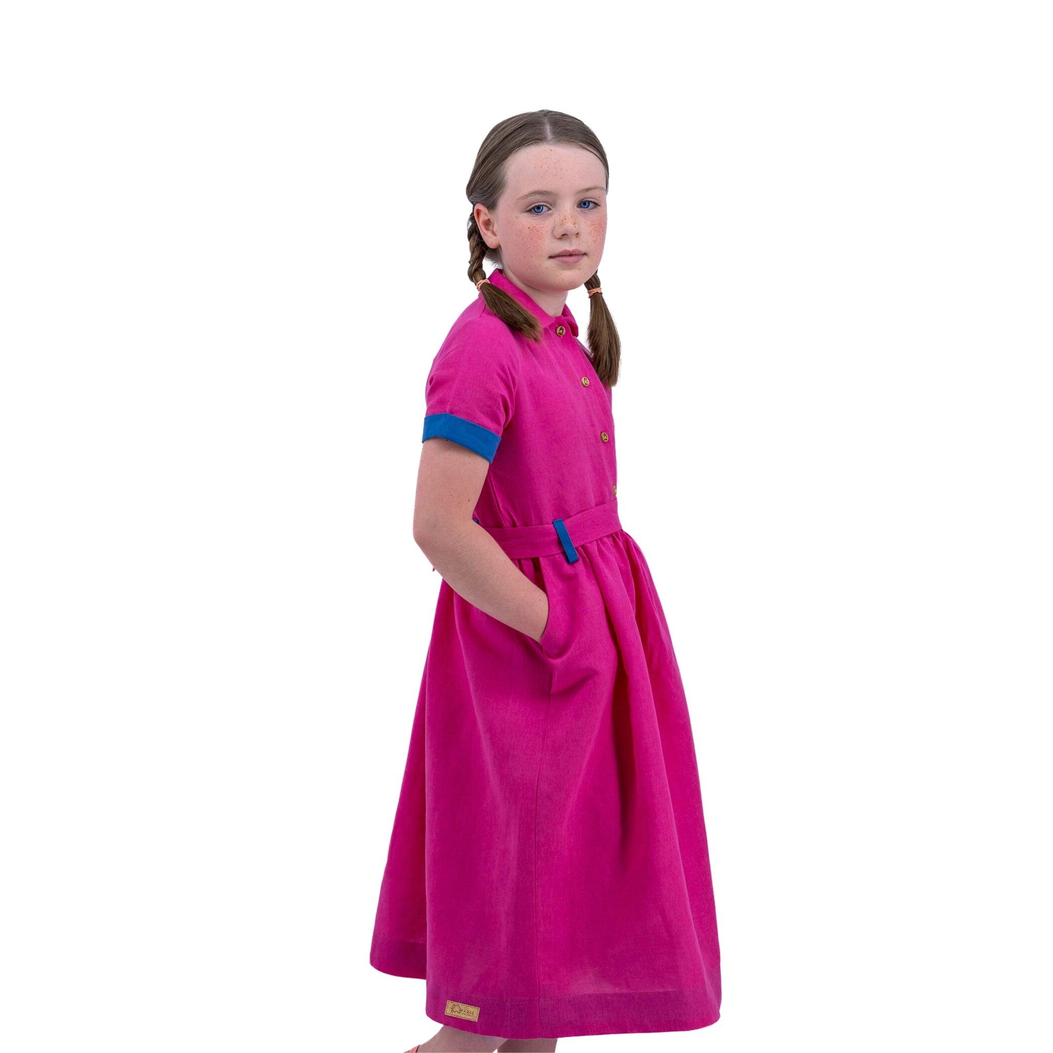 Young girl with braids wearing a Karee Fuchsia Purple Linen Dress for Girls standing against a white background.