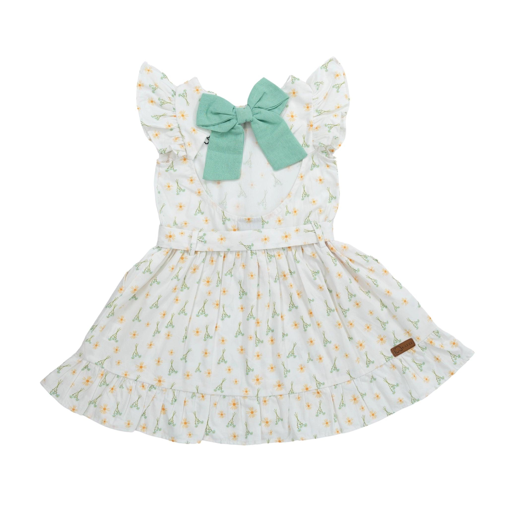 Karee Petite Blossom Cotton Dress in Smoked Pearl: White children's dress with green bow and floral pattern crafted from high-quality cotton, isolated on a white background.