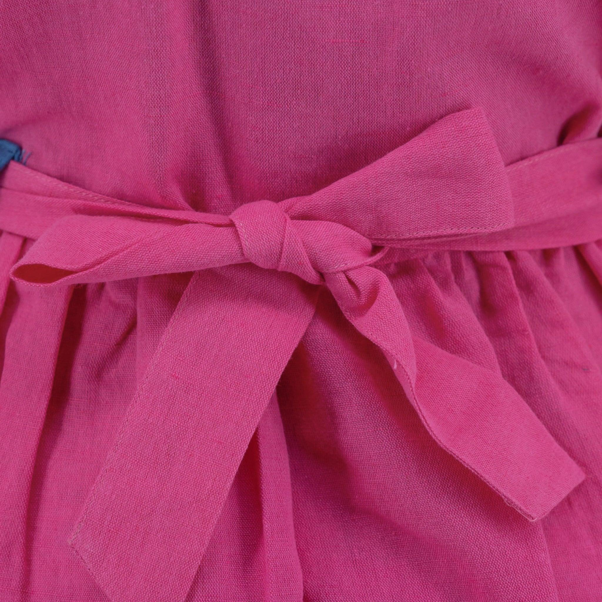 Close-up of a Karee fuchsia purple linen waistband tied in a bow on a garment.