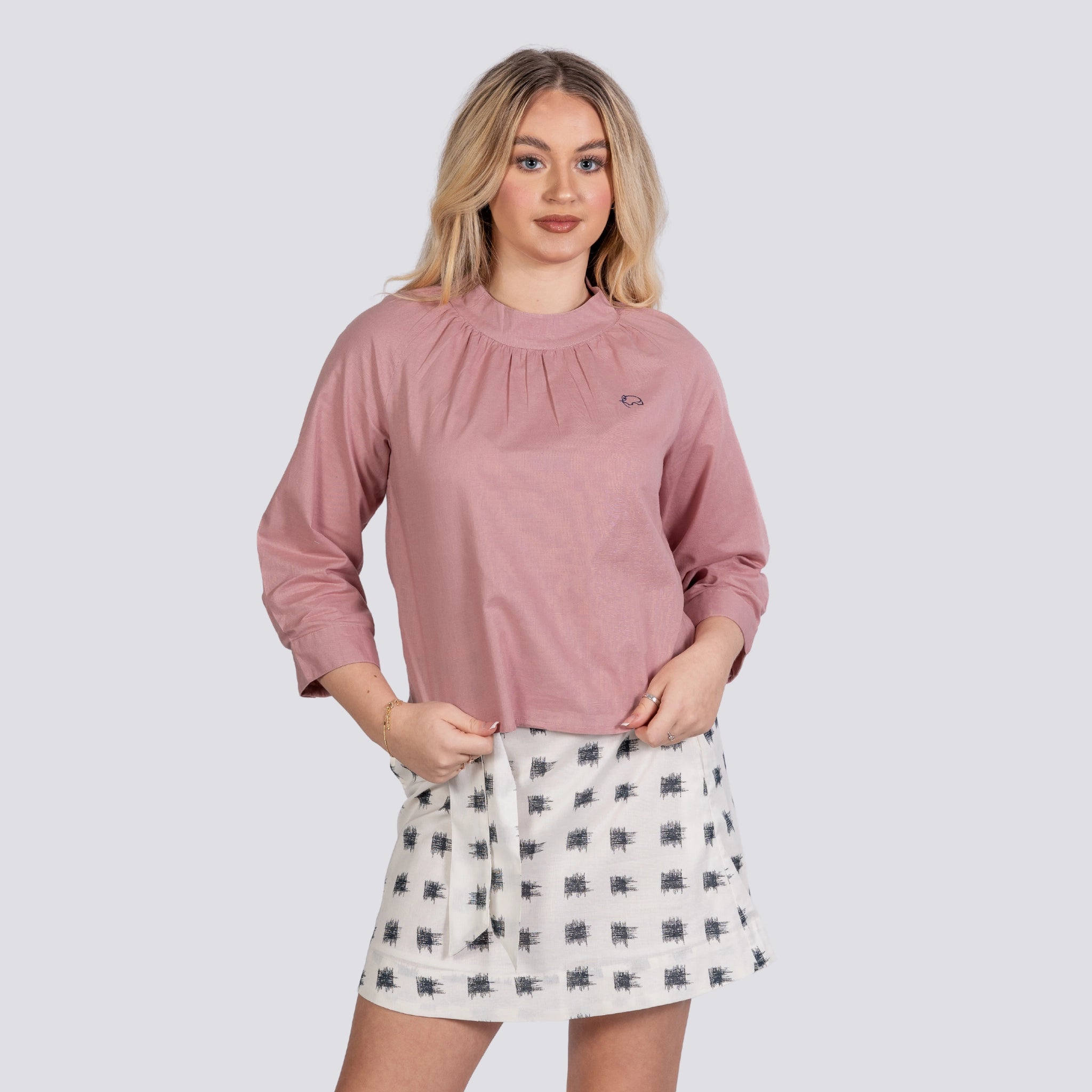 A woman in a pink blouse and a Karee Aqua Haze Elegance Linen Cotton Skirt For Women stands confidently against a gray background.