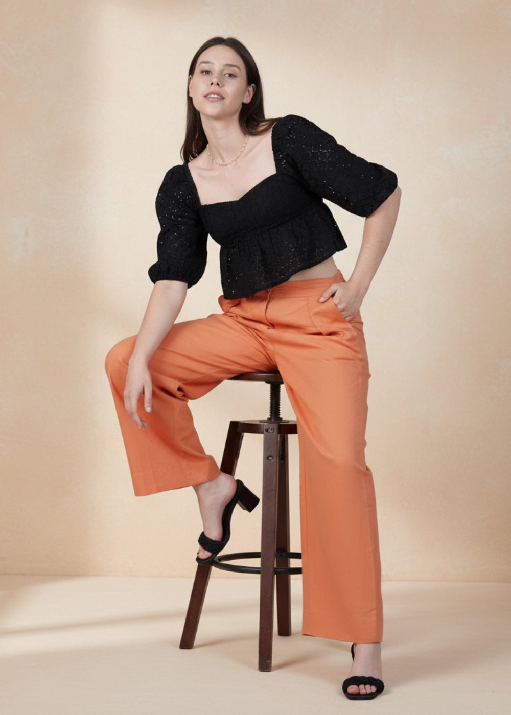 Model wearing Karee’s Deep Saffron Wide-Leg Linen Trousers — sustainable orange linen pants with high waist, pleats, and pockets, ethically made in India.